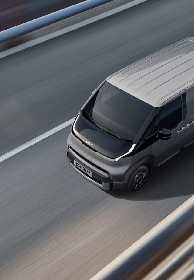 Draufsicht auf den Kia PV5 Passenger bei der Fahrt auf der Autobahn.